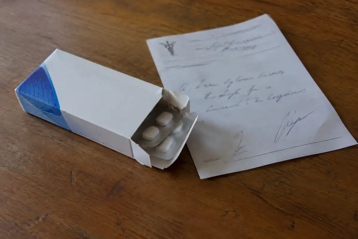 Boîte de médicaments et ordonnance posées sur une table